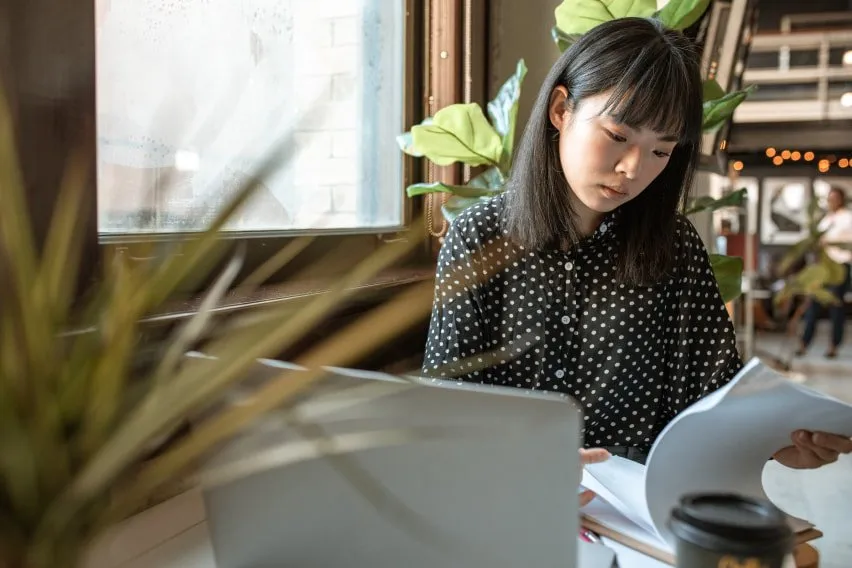 woman working seated at desk and looking at papers